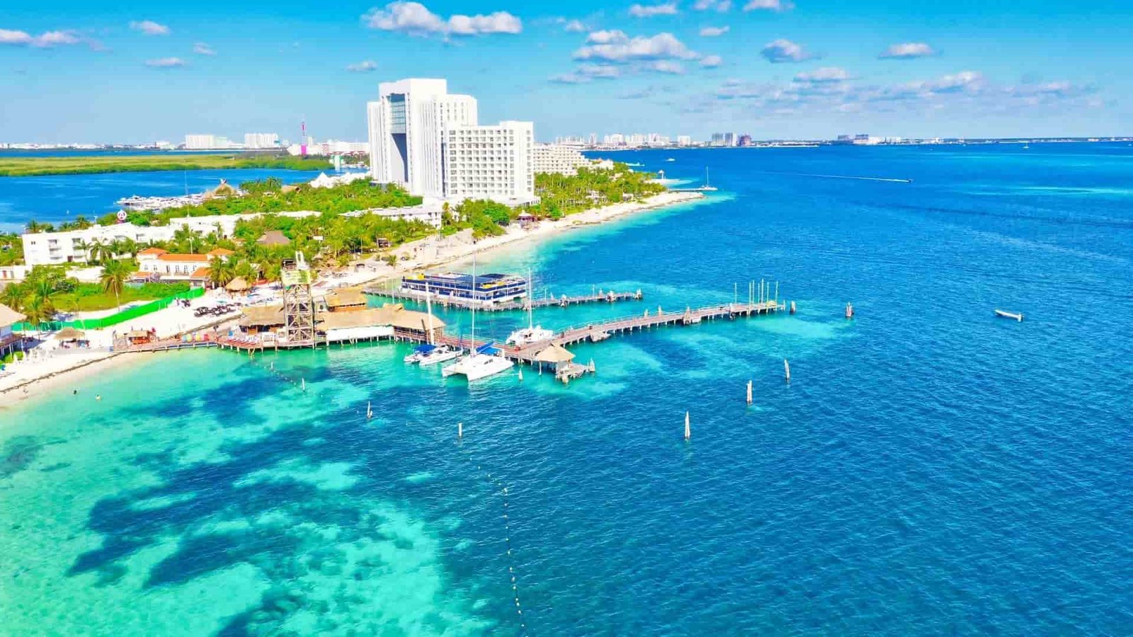 Vista aérea de un puerto en Cancún con aguas turquesas y embarcaciones