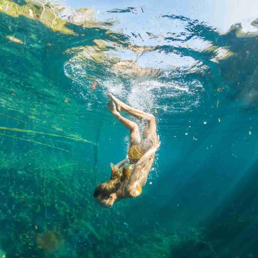 Persona nadando en un cenote en la Riviera Maya